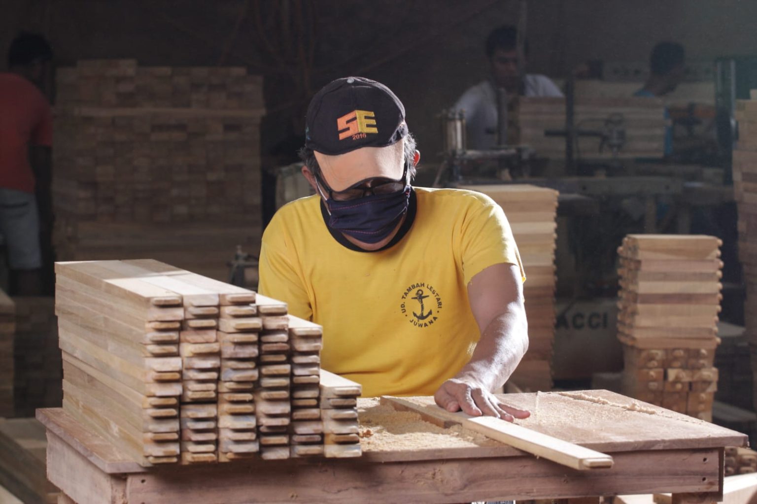 Artisan préparant les lamelles de teck dans notre atelier partenaire — Décors & Bois